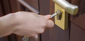 a homeowner opening a BS3621 British Standard lock on their front door