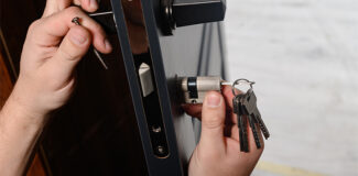 a close up of a homeowner who has changed a door lock